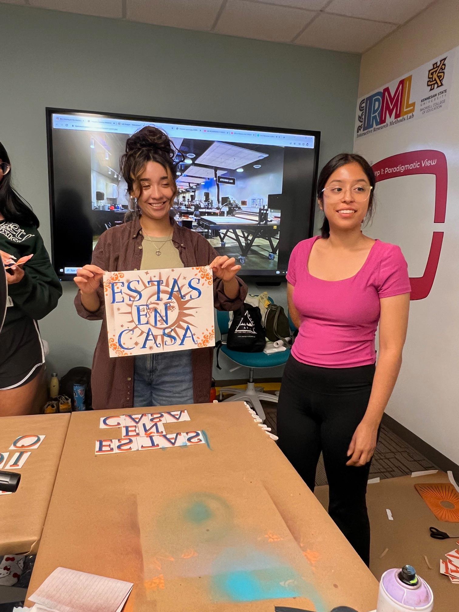  / student holding up their art work.