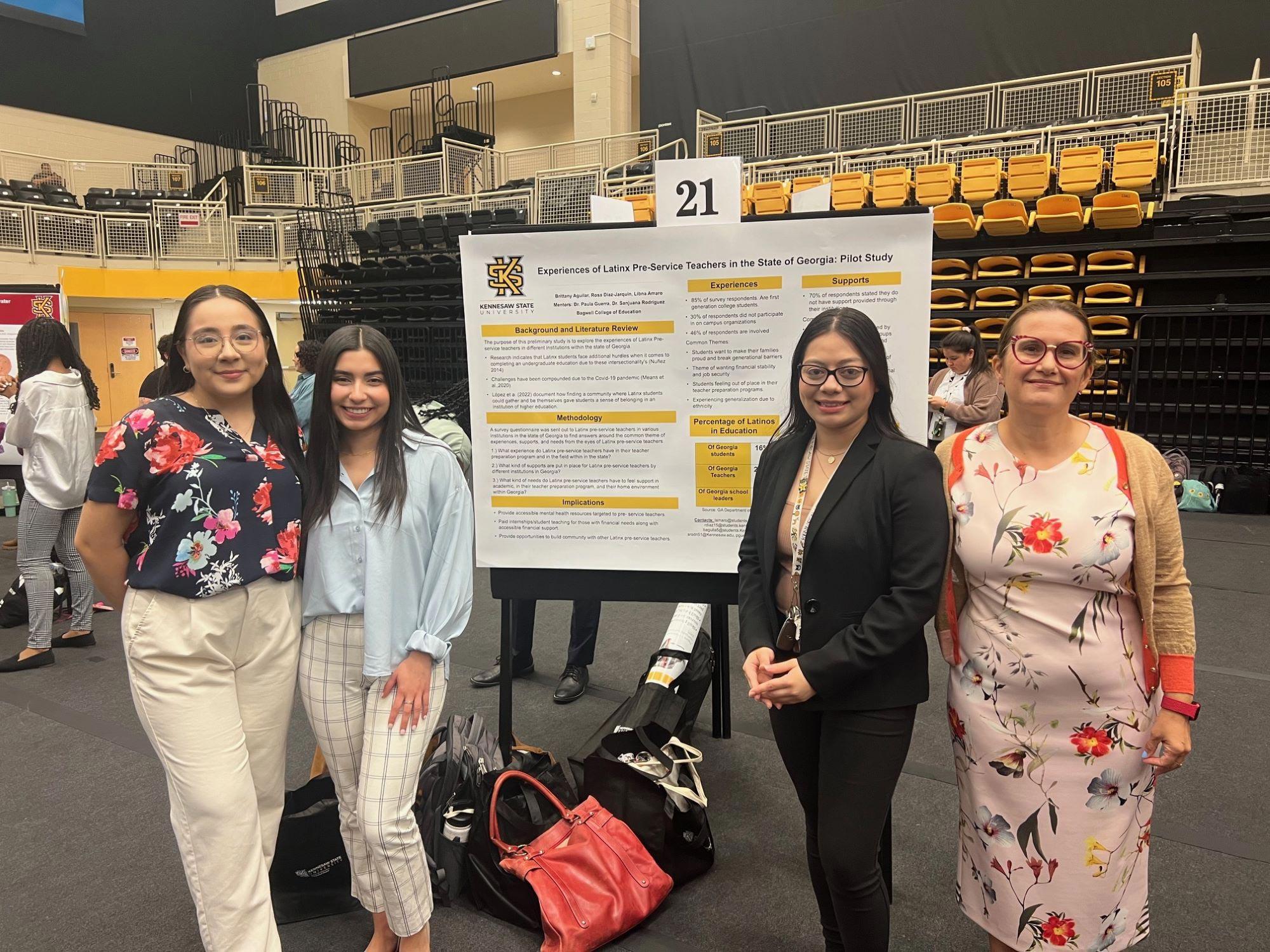  / Students and faculty standing in front of a presentation.