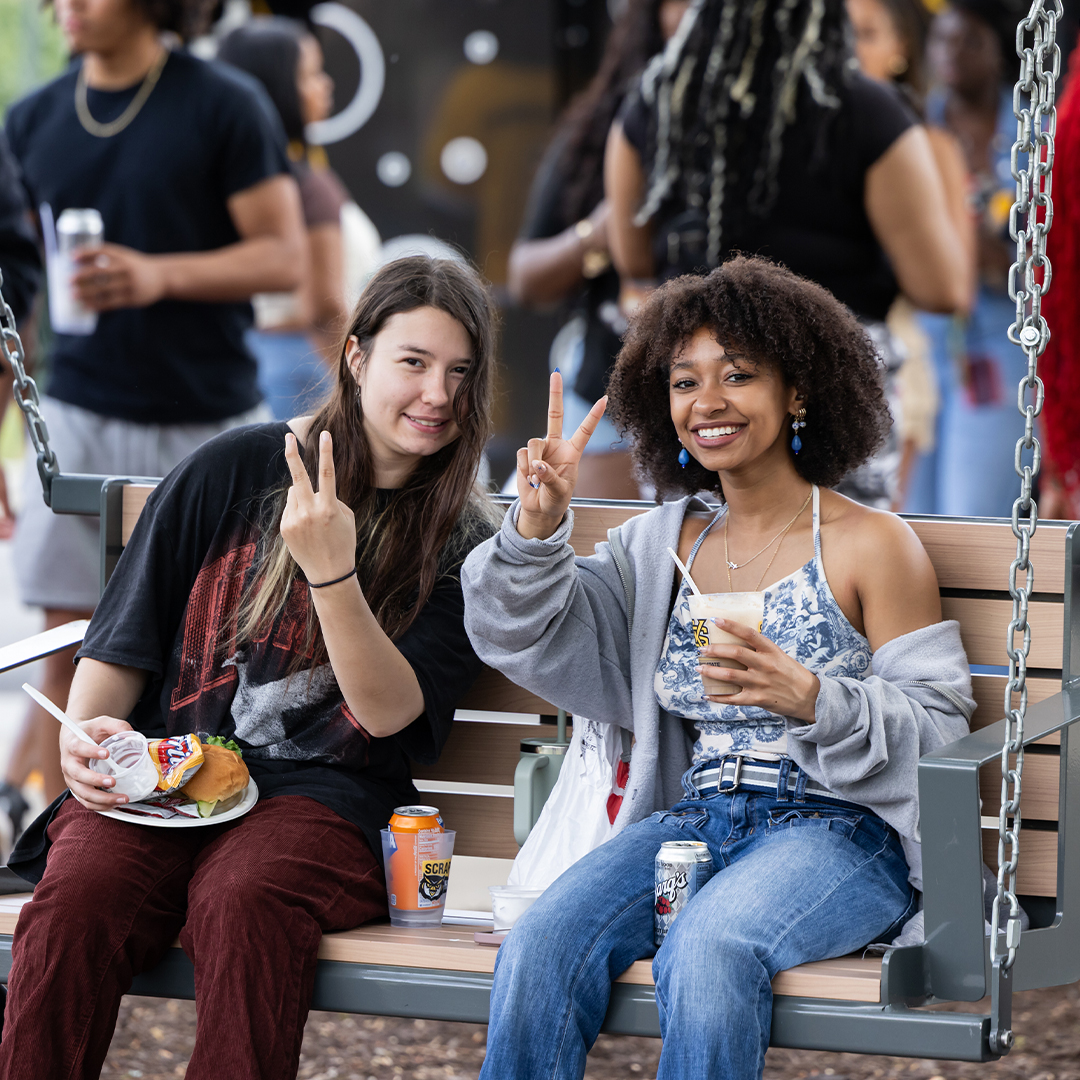 group of students smiling on bench at event