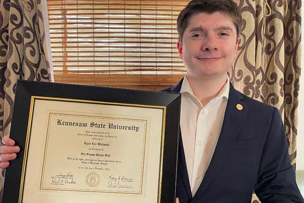 student holding framed certificate