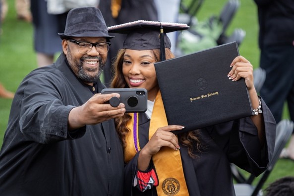 ksu graduate taking photo with diploma
