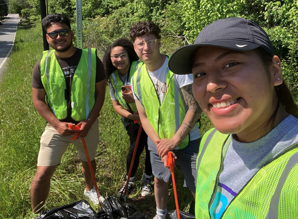 Students picking up trash from the side of the road / 