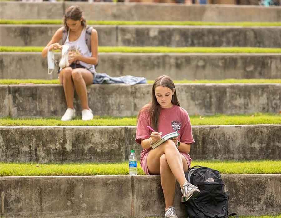 ksu students sitting outside studying on the steps.