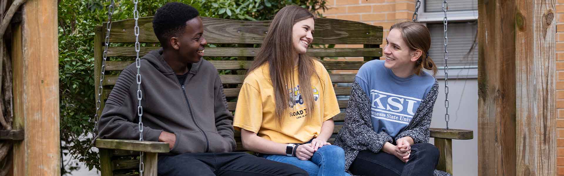 group of ksu students sitting on a bench talking