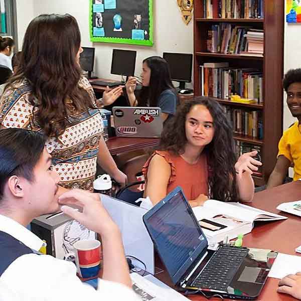 gloval village students talking at a table
