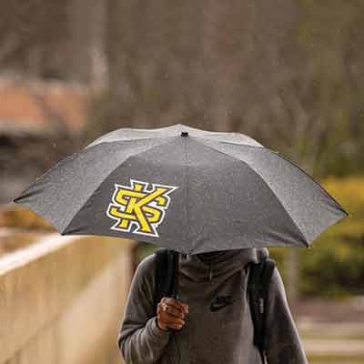 ksu student walking in rain with umbrella
