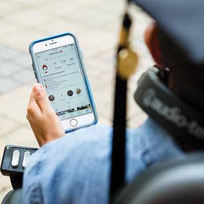 ksu student in wheel chair looking at app on phone