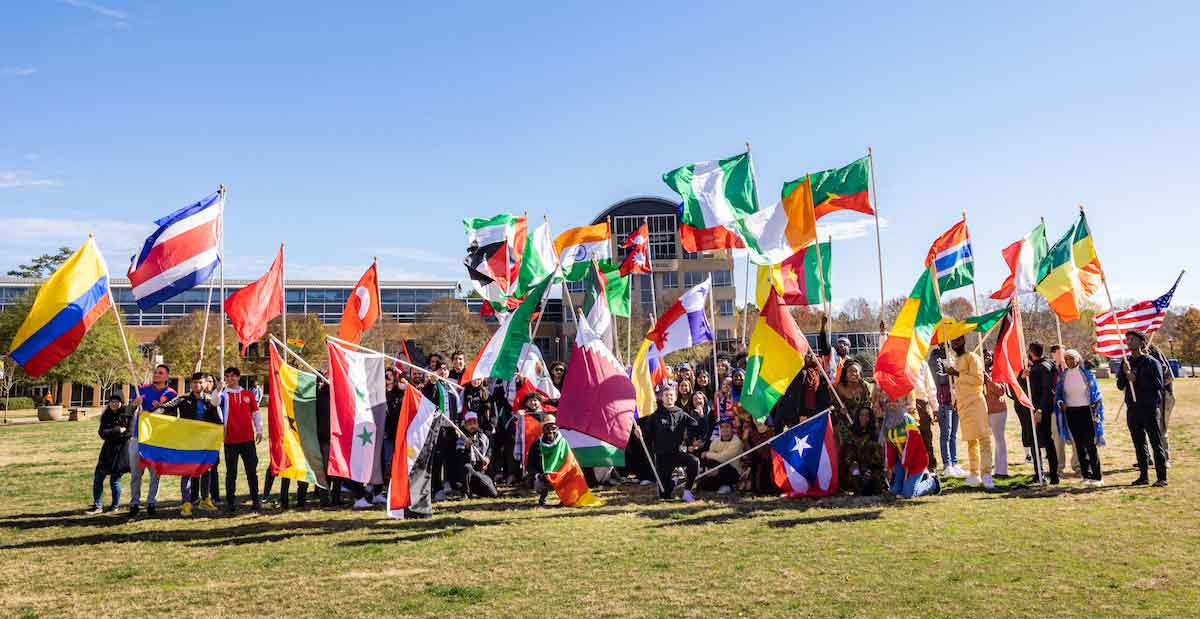 students holding flags on the campus green
