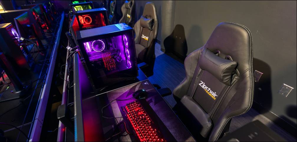 gaming lounge with multiple gaming computers and chairs.