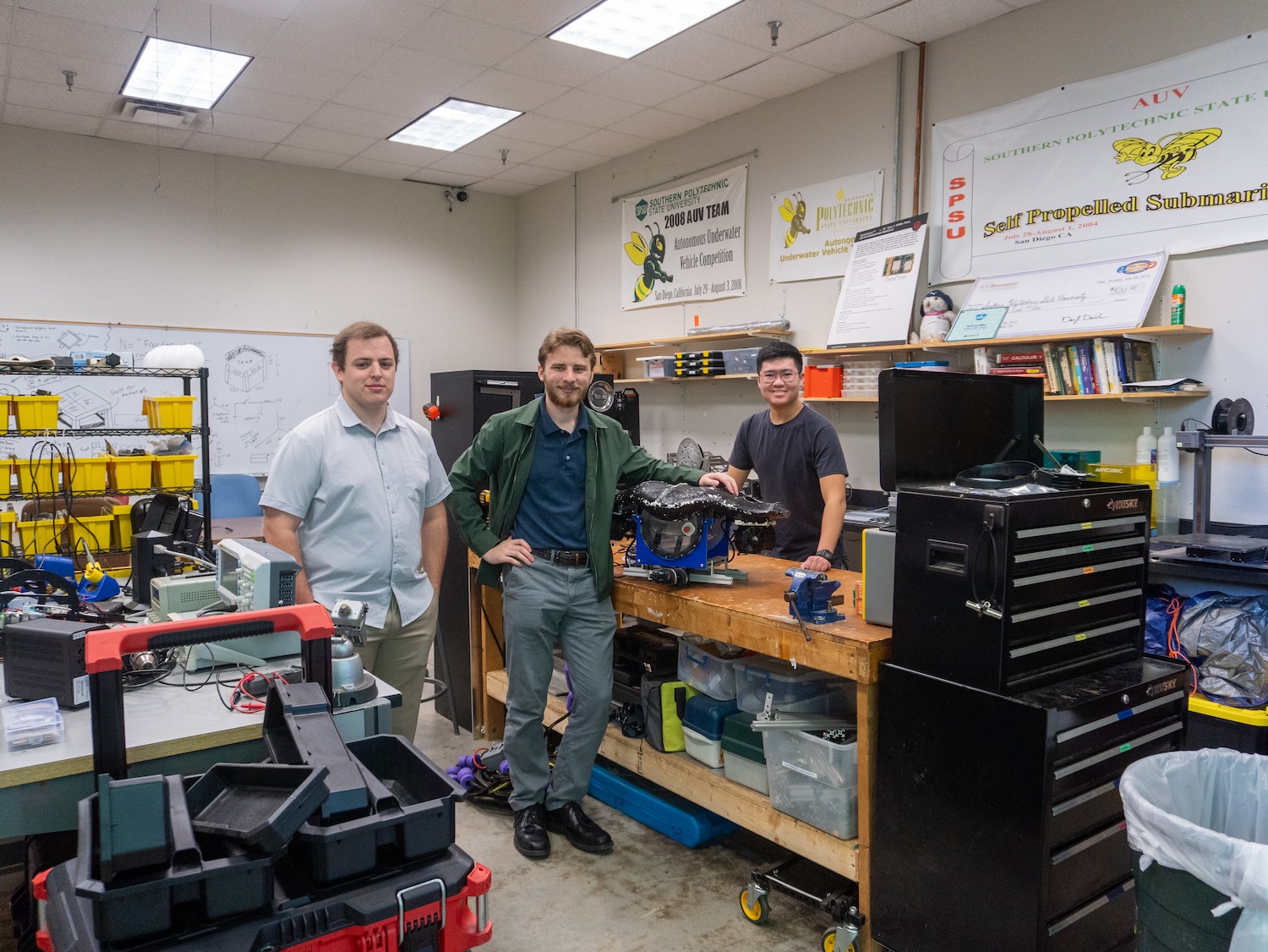 auv team poses with manta in shop