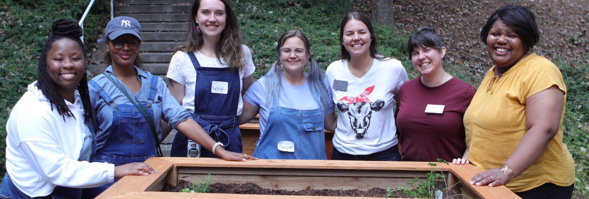 ksu students posing with Marcy Sidum in front of outside planter box