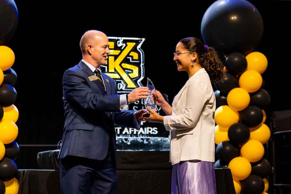 Dr. Eric Arneson hands an award to Sofia Torres