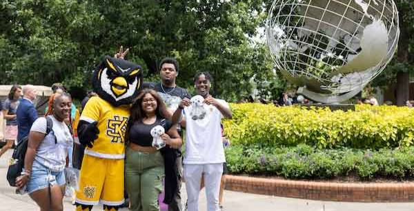 ksu students at the marietta campus by the globe taking a picture with scrappy.