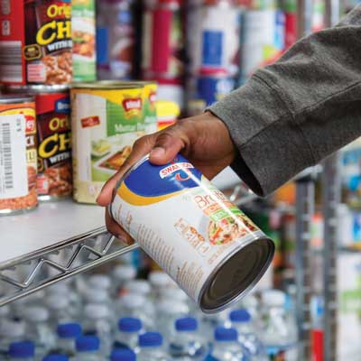 close up of hand holding can in ksu food pantry