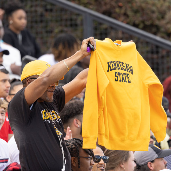 fan holding up ksu fan holding up ksu sweatshirt at football game