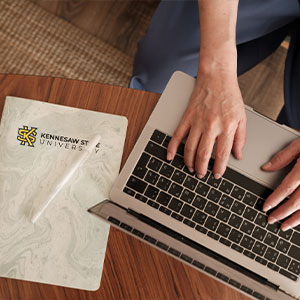 Laptop with KSU notebook and a pen
