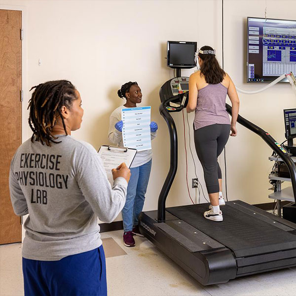 two ksu students monitoring another student exercise on a machine