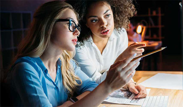 two students working together at computer screen.