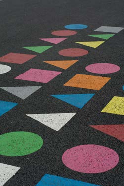  pattern of circles, squares, and triangles in bright colors contrasted on an asphalt surface. Image is titled “DSC_1384” by Michael Poitrenaud