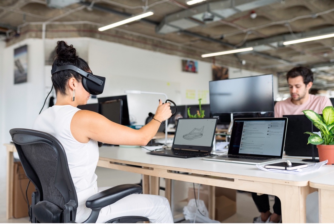 woman playing vr in office man sitting across from her