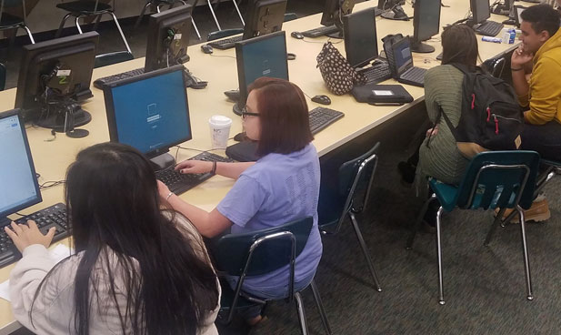 Ola High School Writing Center with a view of the LAB where students are helping each other.